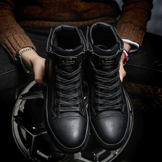 Person holding a pair of black high-top sneakers with a blurred background