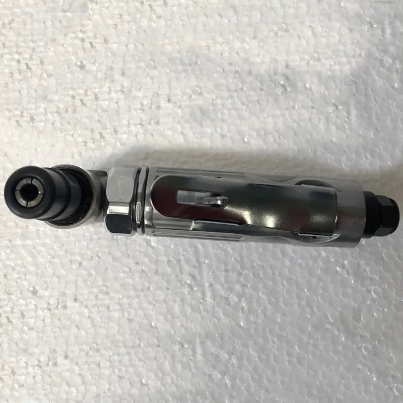 Metal tool with black components on a textured white background