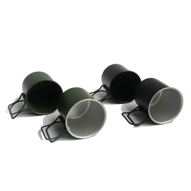 Set of four metal cups with black holders on a white background
