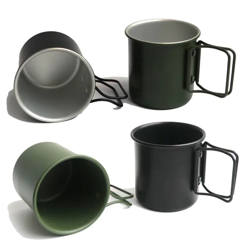 Set of black and green metal mugs with handles on a white background