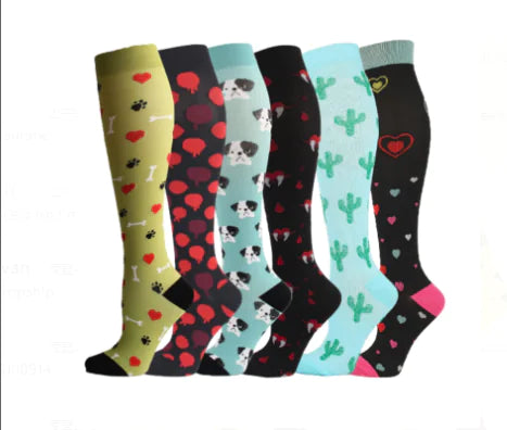 Set of six colorful compression knee-high socks with various patterns like puppies, hearts, cactus, on a white background