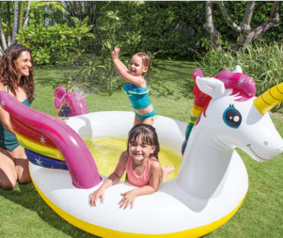 Children playing in a unicorn-shaped inflatable pool in a garden setting.