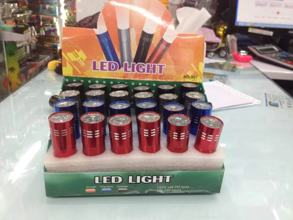Cardboard Display of LED mini flash lights on a glass surface with messy desk in the background