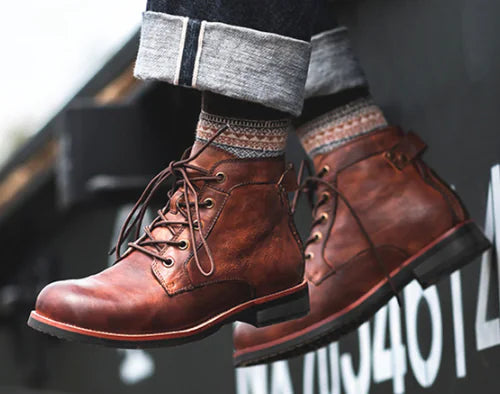 Men's Brown leather laceup ankle boots being worn by someone dangling their feet