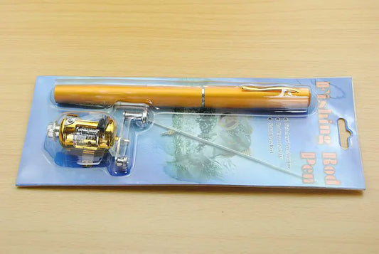 Fishing rod pen set with gold reel on a blue card packaging against a wooden surface.