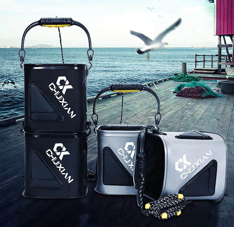 Four black and gray fishing water buckets with 'CHUXIAN' branding on a dock with ocean and seagull background.