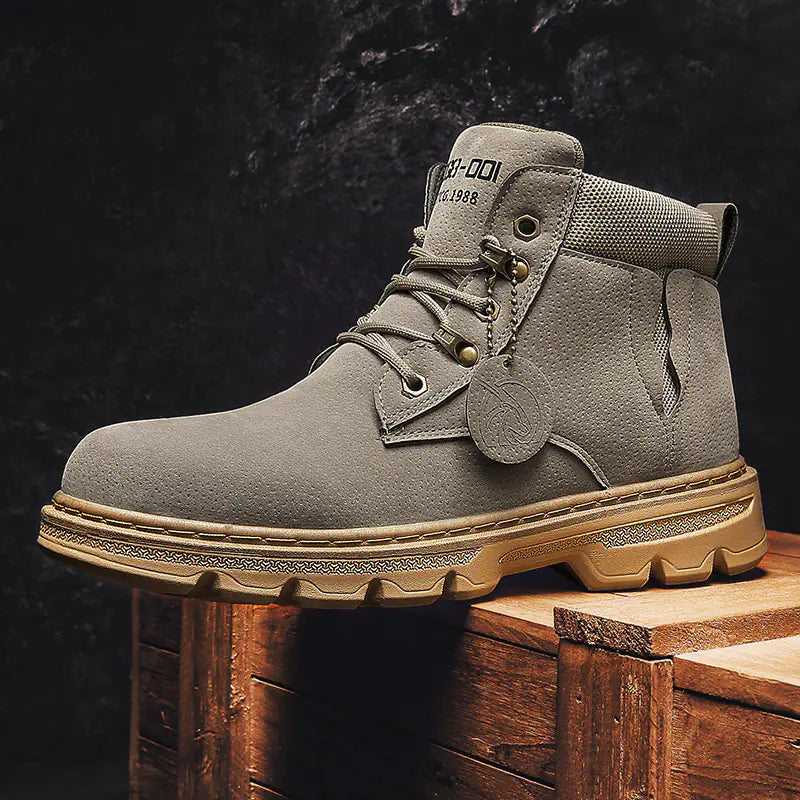 Gray boot with beige sole on a wooden block against a dark background
