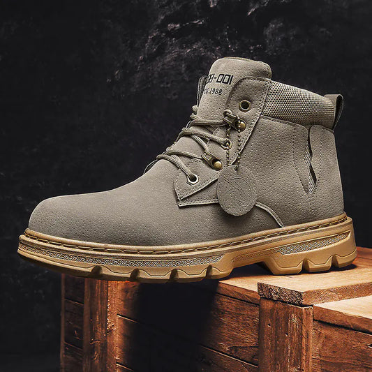 Gray boot with beige sole on a wooden block against a dark background
