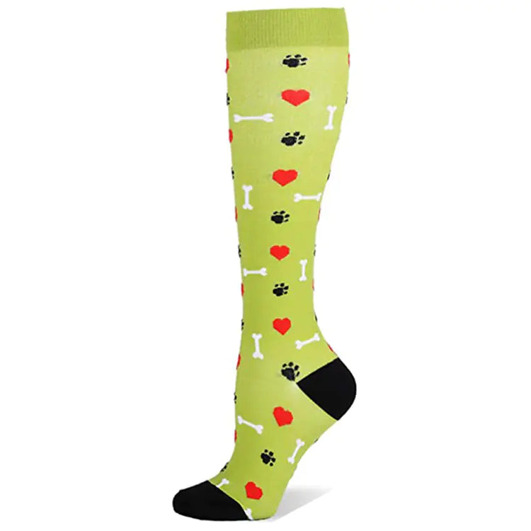 Green knee-high compression sock with heart and paw print  and dog bones patterns on a white background