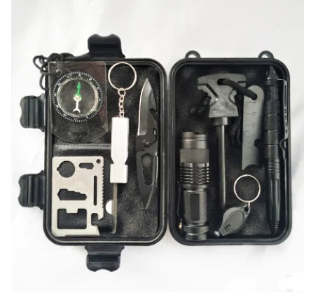 Outdoor survival kit with tools including a knife, flashlight, and multitool in a black case on a white background.
