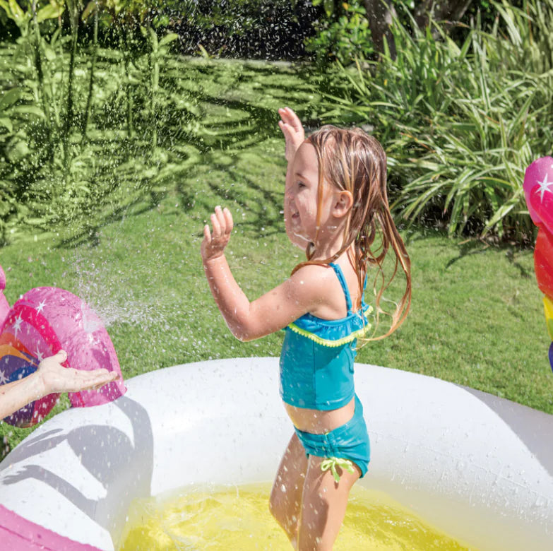 Child playing with water in a inflatable pool outdoors