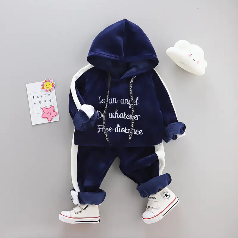 Navy blue hoodie and pants set with white sneakers on a gray background