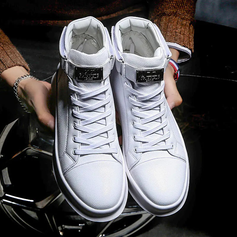 White high-top sneakers held by a person with a dark background