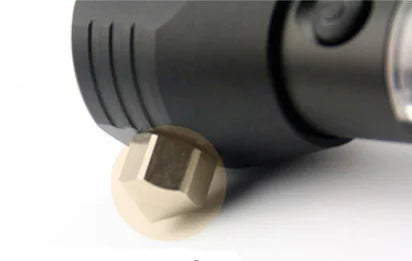 Close-up of a black flashlight with a brass hexagonal hammer glass breaking head on a white background
