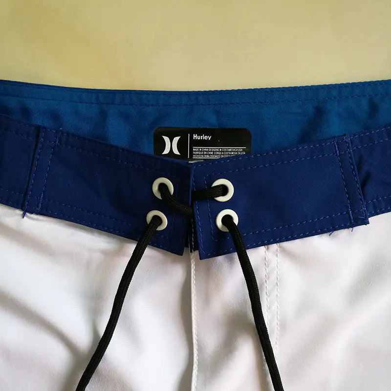 Close-up of a waistband of men's board shorts with a Hurley label on a white background
