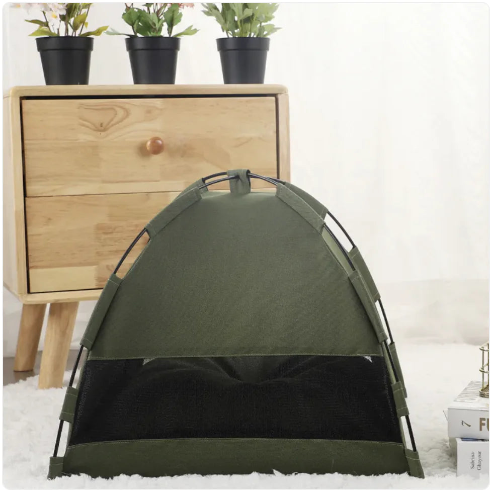 Back view of Green pet cooling tent on a white surface with a wooden cabinet and potted plants in the background.