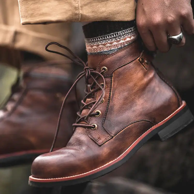 Men's Brown leather laceup ankle boots man reaching down and adjusting them