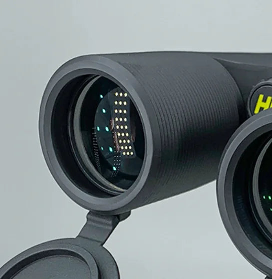 Close-up of a black binoculars with a visible brand logo on a light gray background
