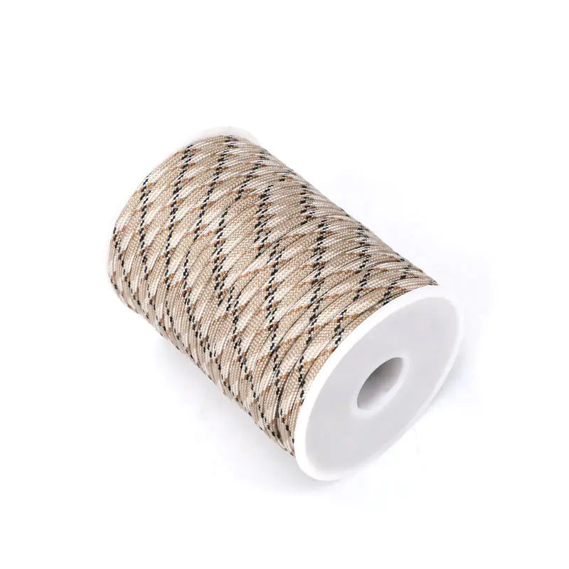 Spool of beige thread with black stripes on a white background